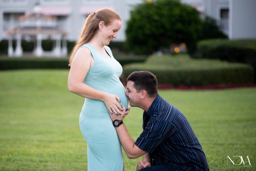 Dad-to-be kissing belly during maternity photos at Disney's Beach Club Resort.