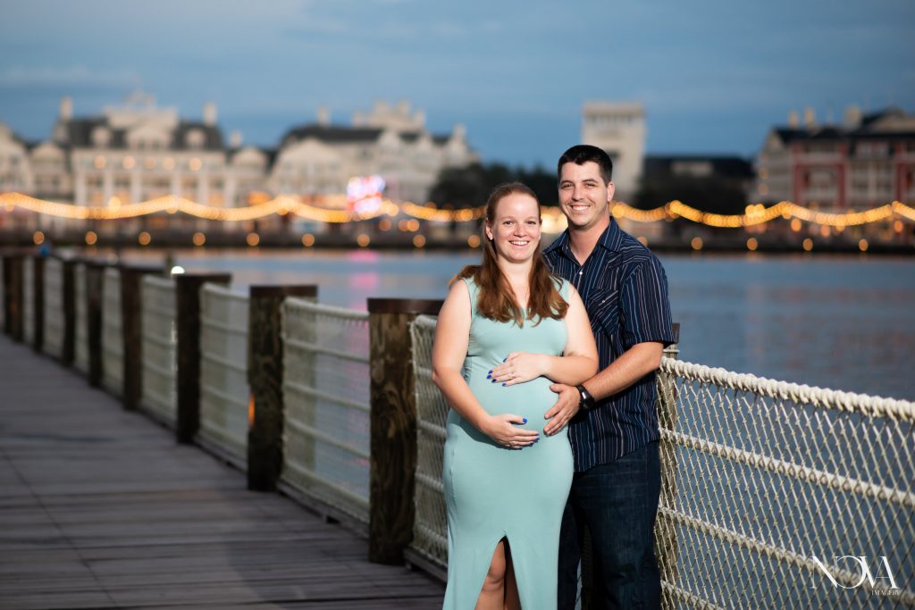 Happy couple posing on the dock of Disney’s Beach Club Resort for their maternity photos.