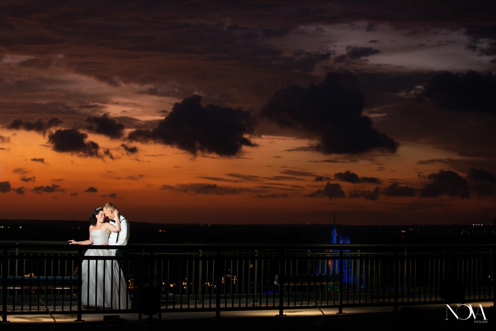 Bride and groom embracing on a bridge at night