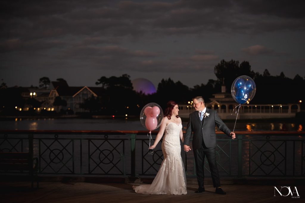 Bride and groom holding Mickey Mouse balloons at Epcot.