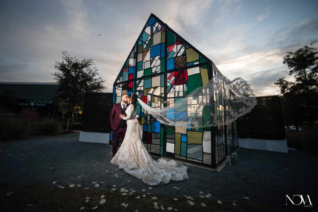 Bride and groom kissing outside a stained glass chapel in Orlando
