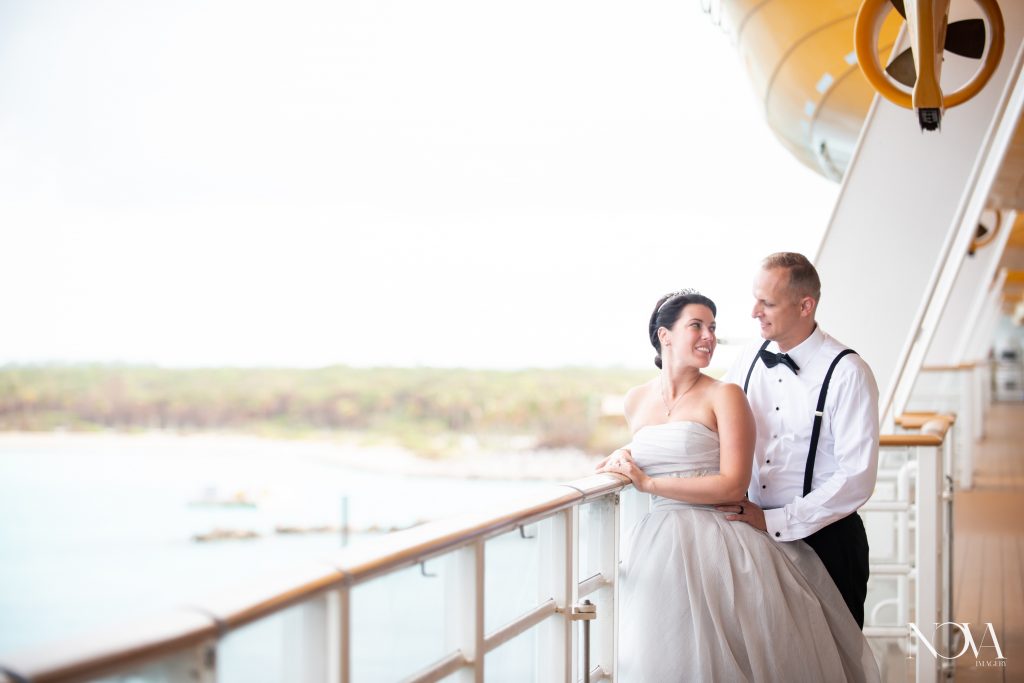 Bride and groom smiling at each other, overlooking castaway cay island.