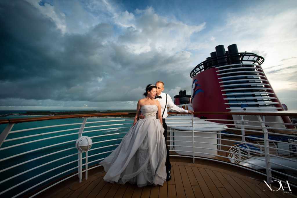 Groom kisses bride’s temple during their sunrise Disney cruise wedding photoshoot.