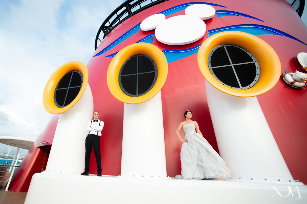 Couple posing on the deck outside during their Disney cruise wedding photoshoot.
