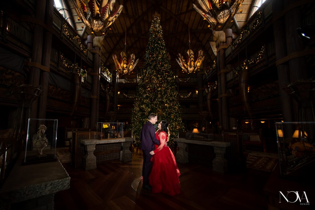 Couple in front of Christmas tree during their Animal Kingdom Lodge photo session.