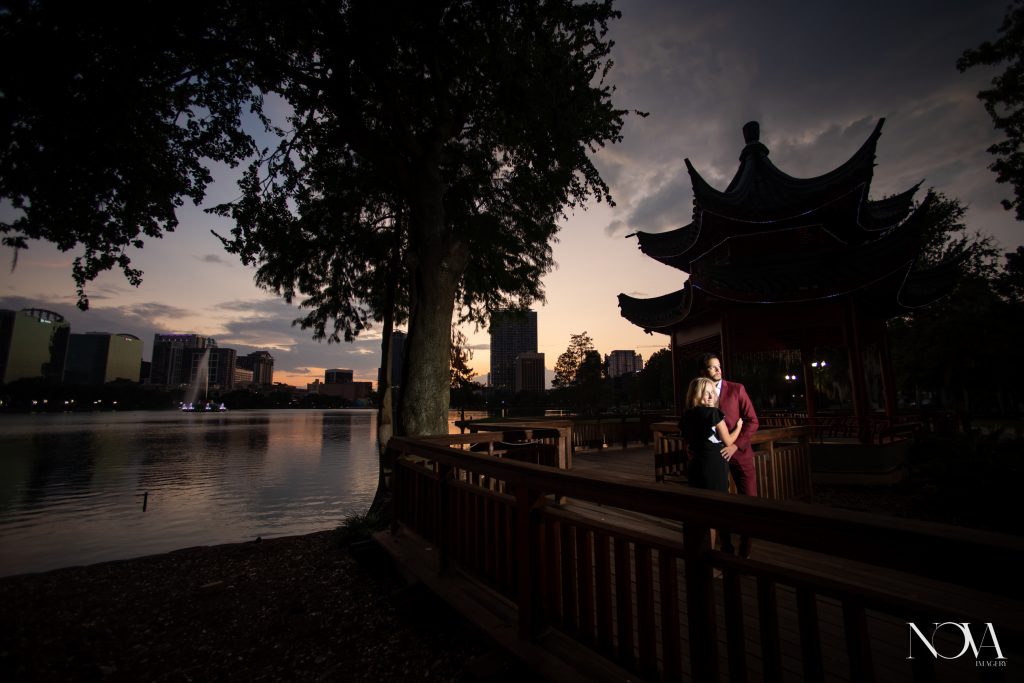 Engaged couple posing in front of the red Pagoda for their Lake Eola engagement session.