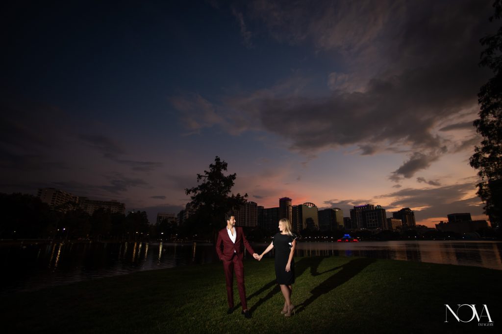 Engaged couple holding hands during sunset for their Lake Eola engagement session.