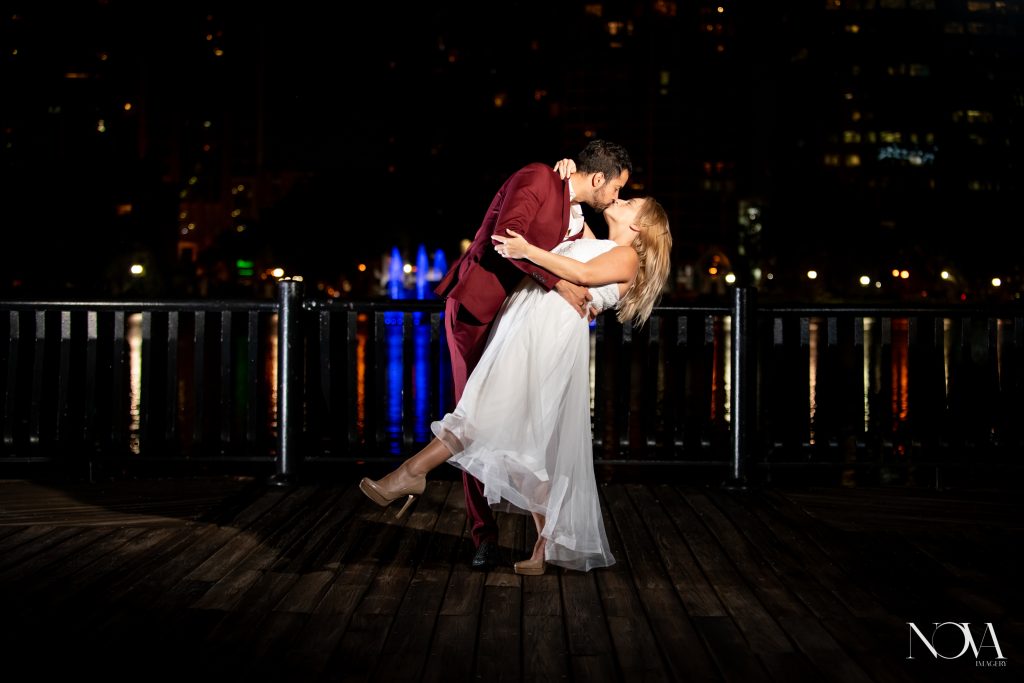 Couple kissing during their nighttime Lake Eola engagement session.