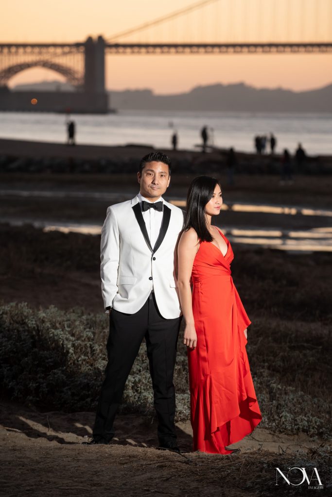 Engaged couple in formal attire at the Golden Gate Bridge during their San Francisco engagement session.