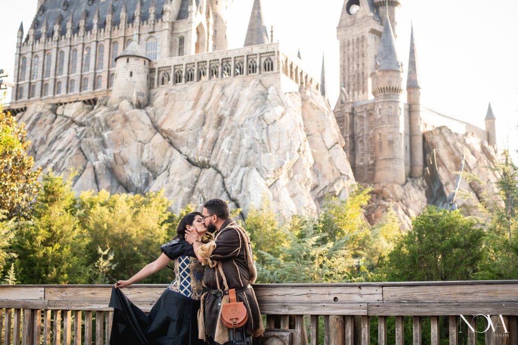 Couple kissing in front of Hogwarts castle.
