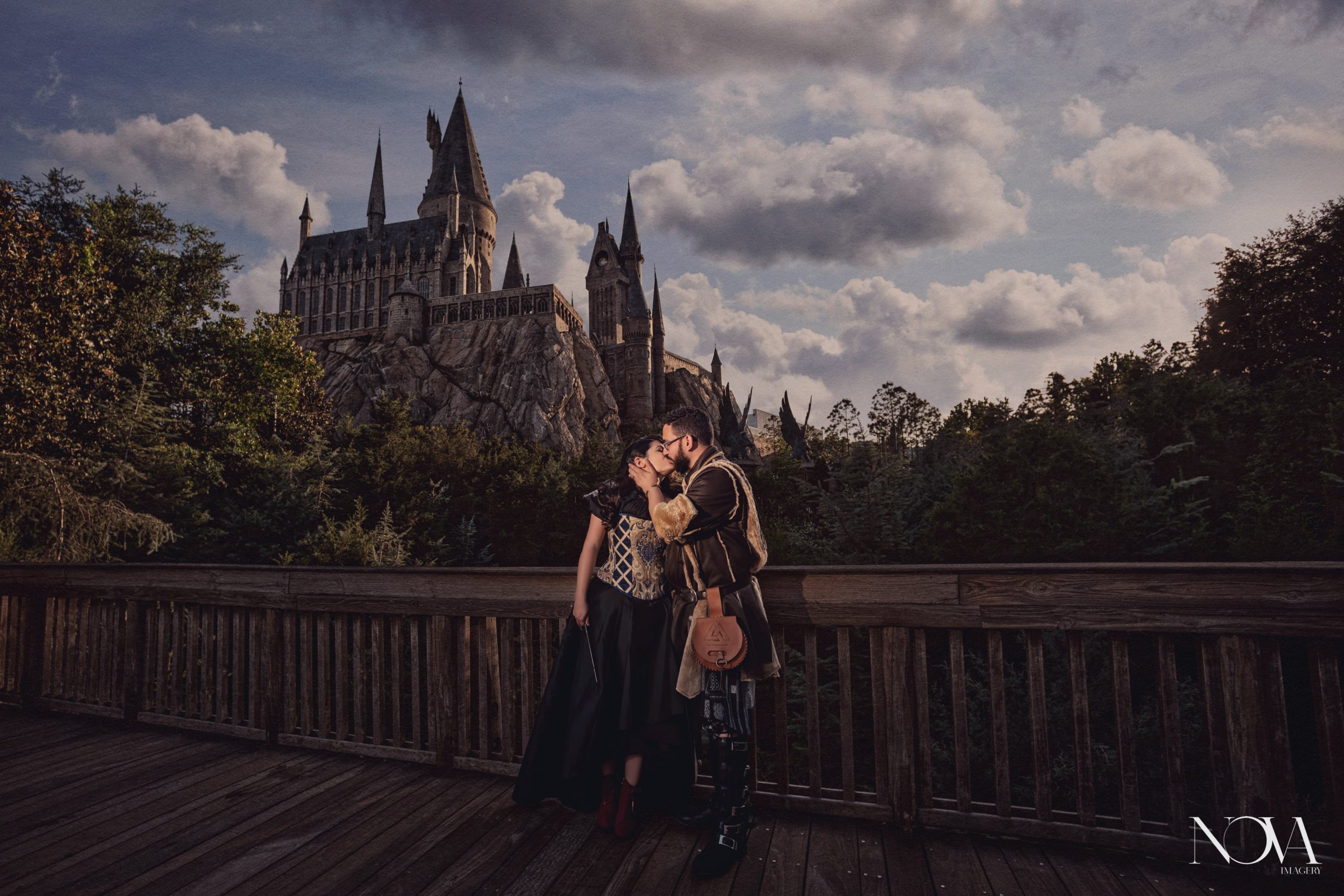 Engaged couple kissing in front of Hogwarts castle at Island of Adventure