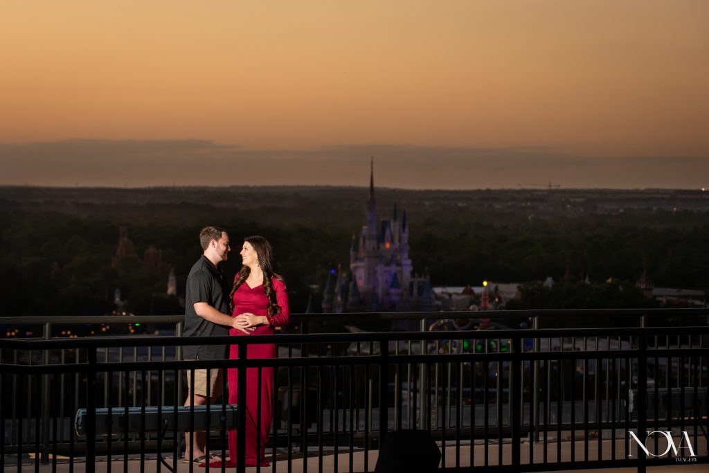 Expecting couple holding pregnant belly on the catwalk during maternity session at Disney’s Contemporary.