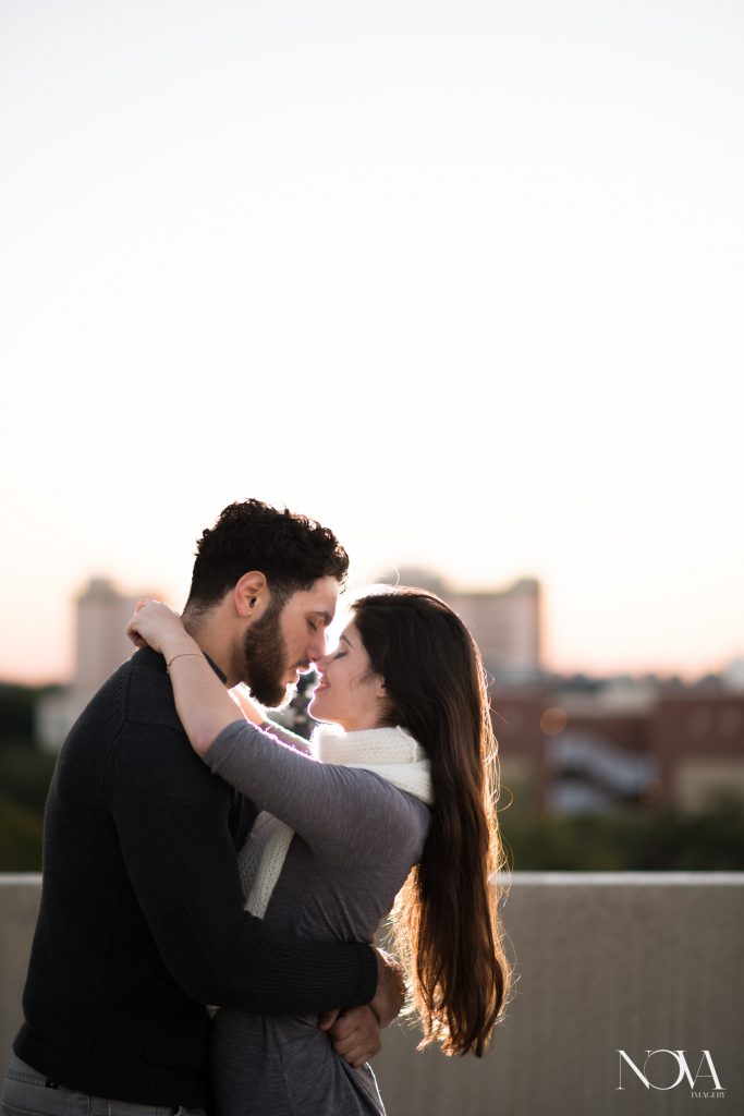 Couple kissing on parking garage rooftop in Downtown Orlando for engagement photos