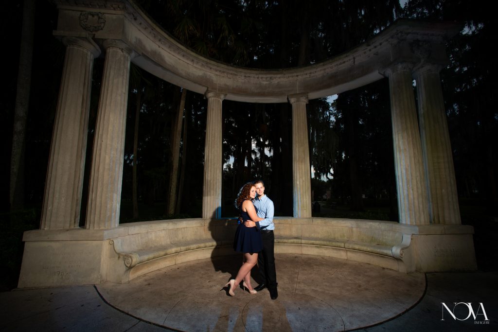 Couple holding each other in front of the columns at Kraft Azalea  Garden