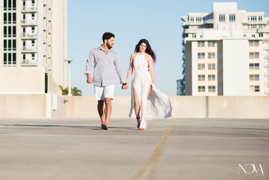 Couple candidly walking on rooftop during their Downtown Orlando engagement photos