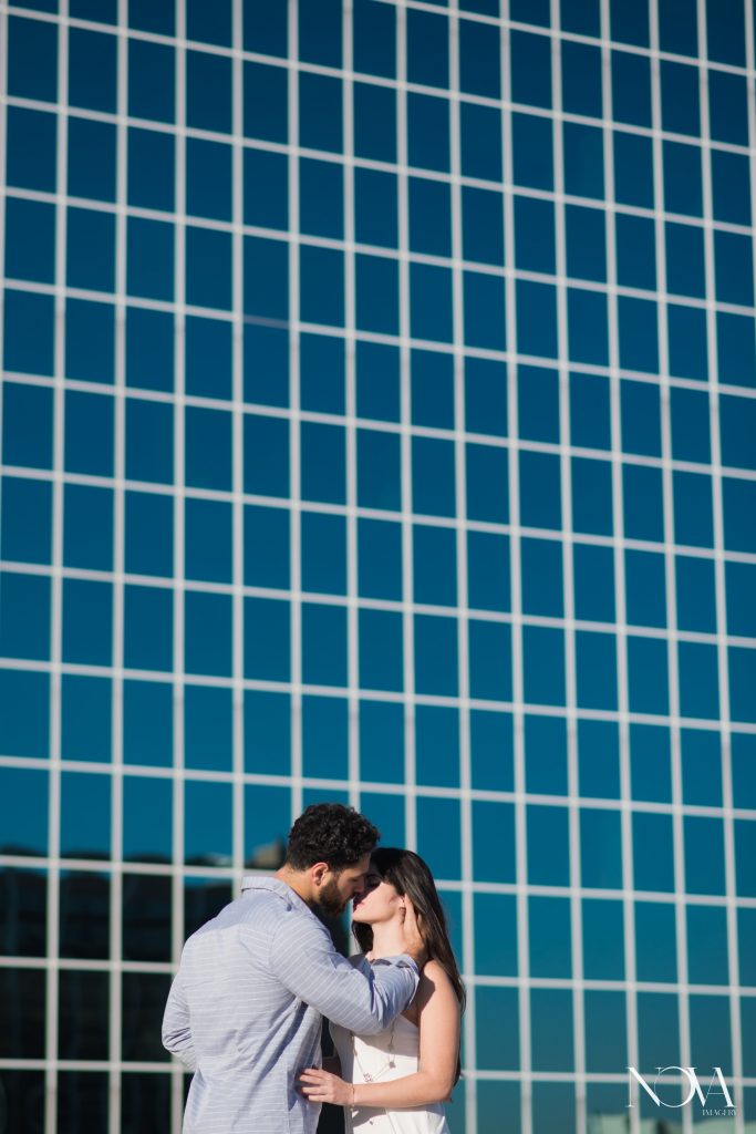 Couple kissing on Downtown Orlando rooftop for engagement photos.