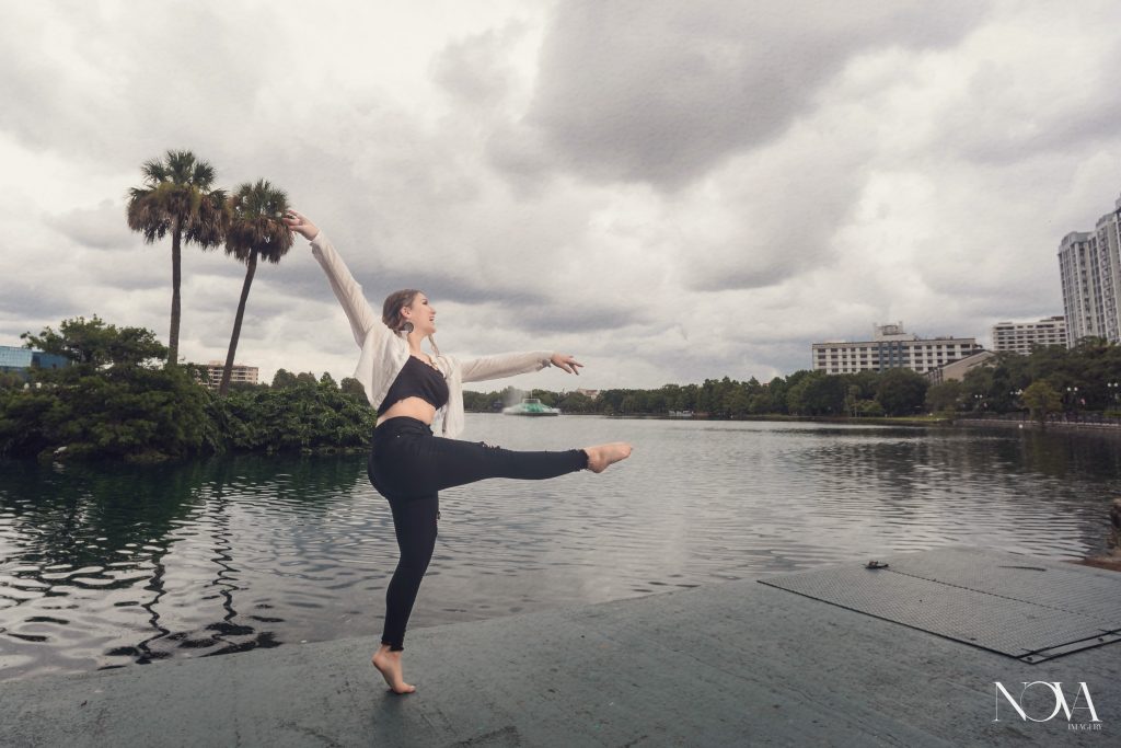 Caterina dancing by the water during her senior photoshoot at Lake Eola Park. 