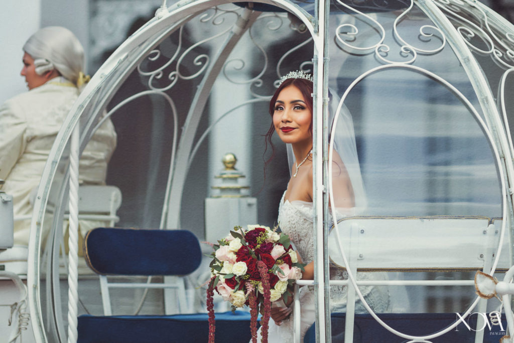 Wedding photography of bride inside of Cinderella's carriage on the way to disney's wedding pavilion