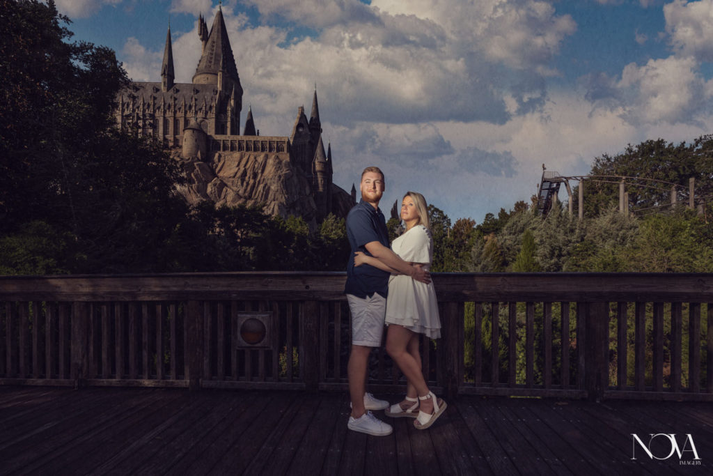 Couple poses in front of Hogwarts Castle after proposal photography