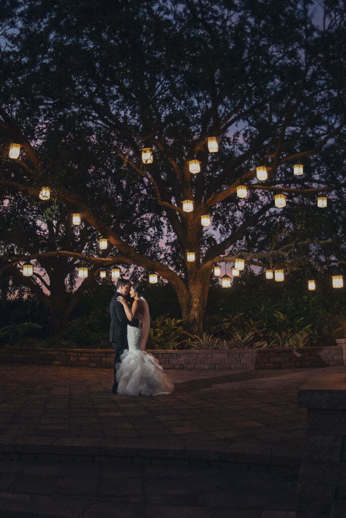 Bride and groom under lanterns at wedding venue, Hyatt Regency Grand Cypress.