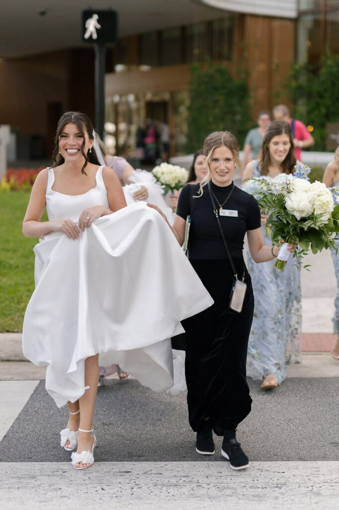 Ellis helping a bride carry her dress and bouquet